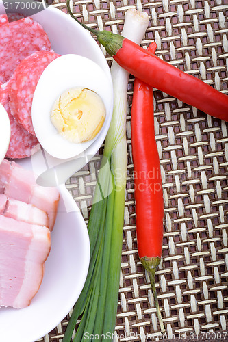 Image of salami with pieces of cheese and red pepper