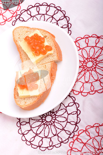 Image of sandwich with red caviar on white plate