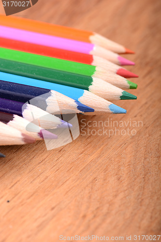 Image of colored pencils  on wooden background