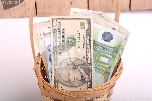 Image of money set in a basket, dollars, euro and ukrainian money