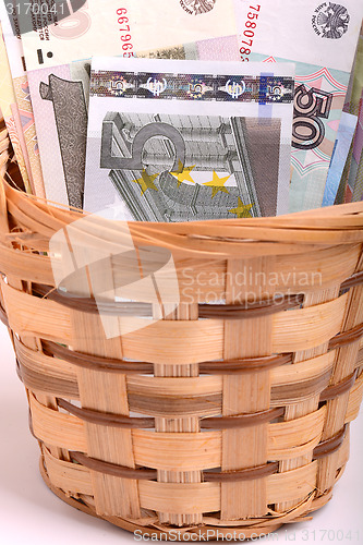 Image of money set in a basket, dollars, euro and ukrainian money