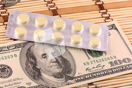 Image of Pills and american money close-up background