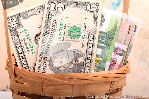 Image of money set in a basket, dollars, euro and ukrainian money