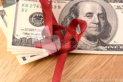 Image of Bundle of dollars tied with ribbon