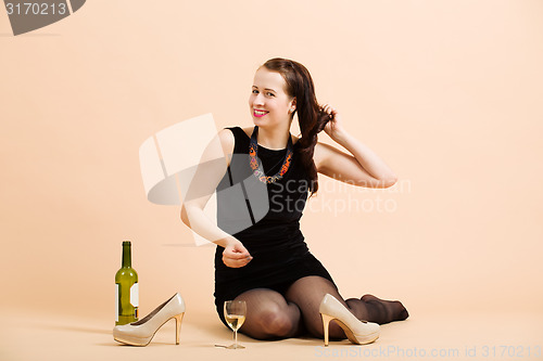 Image of beautiful young brunette woman holding a glass of white wine