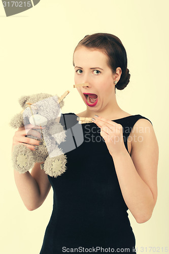 Image of attractive smiling brunette holding teddy bear