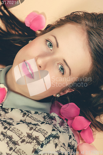 Image of atractive brunette girl lying on beige background