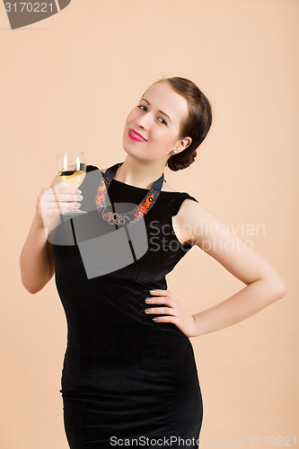 Image of beautiful young brunette woman holding a glass of white wine