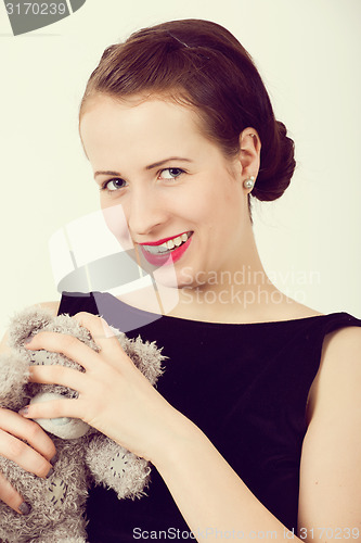 Image of attractive smiling brunette holding teddy bear