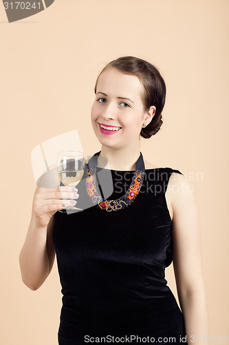 Image of beautiful young brunette woman holding a glass of white wine