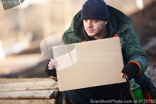 Image of Homeless man holds blank cardboard for your text