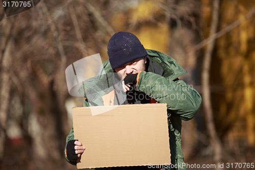 Image of Homeless man holds blank cardboard for your own text