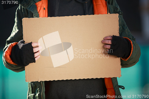 Image of Homeless man holds blank cardboard for your own text