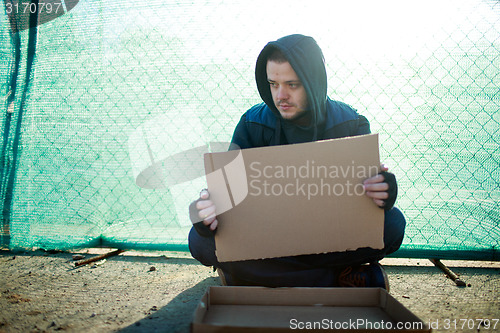 Image of Homeless man holds blank cardboard for your text