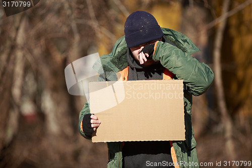 Image of Homeless man holds blank cardboard for your own text