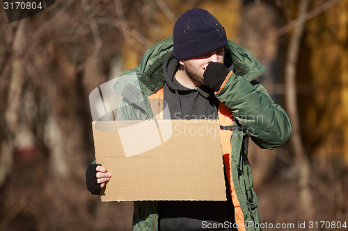 Image of Homeless man holds blank cardboard for your own text