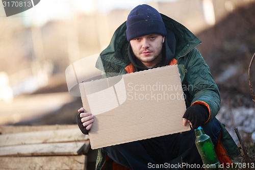 Image of Homeless man holds blank cardboard for your text