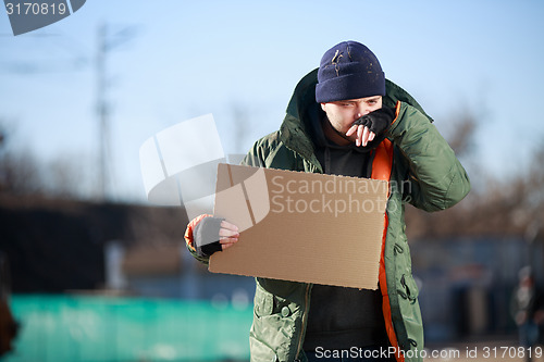 Image of Homeless man holds blank cardboard for your own text