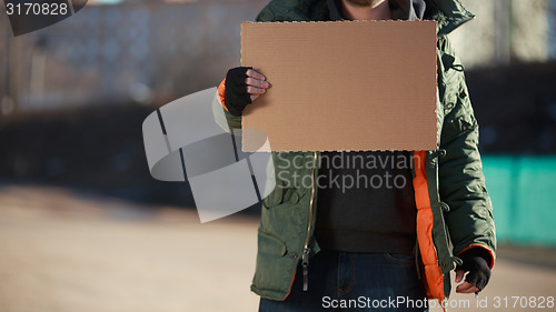 Image of Homeless man holds blank cardboard for your own text