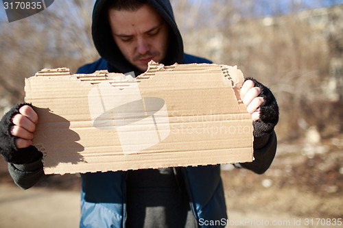 Image of Homeless man holds blank cardboard for your text