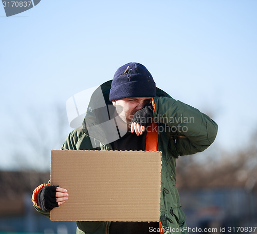 Image of Homeless man holds blank cardboard for your own text