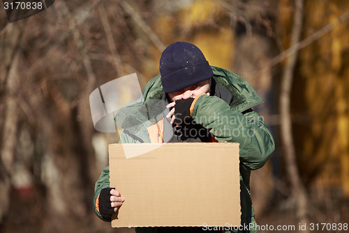 Image of Homeless man holds blank cardboard for your own text