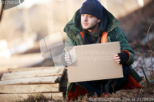 Image of Homeless man holds blank cardboard for your text