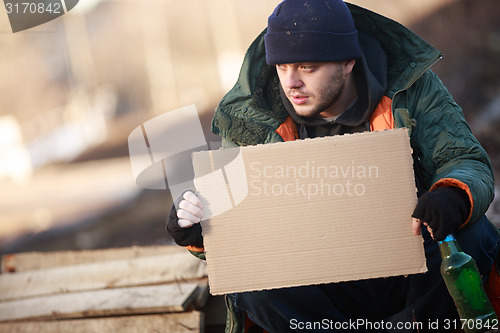 Image of Homeless man holds blank cardboard for your text