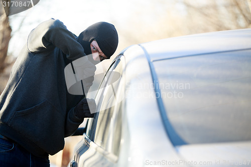 Image of Thief stealing automobile car at daylight street in city