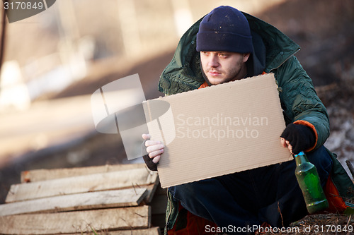 Image of Homeless man holds blank cardboard for your text