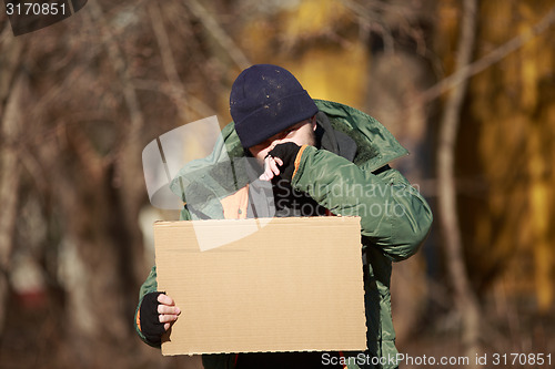 Image of Homeless man holds blank cardboard for your own text