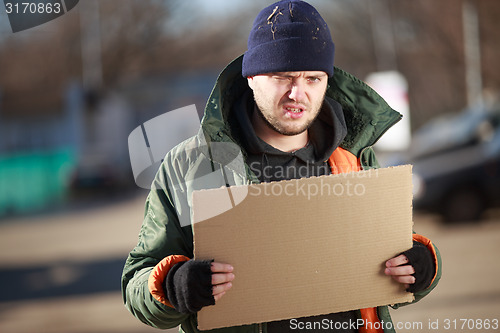 Image of Homeless man holds blank cardboard for your own text