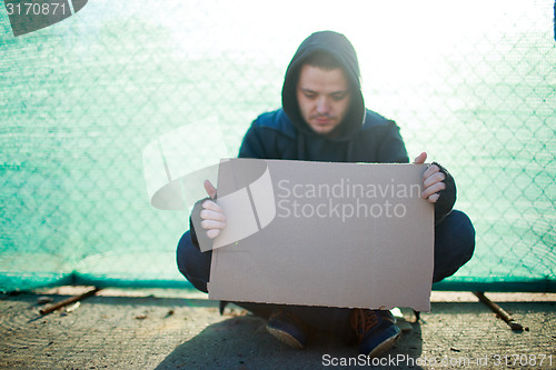 Image of Homeless man holds blank cardboard for your text