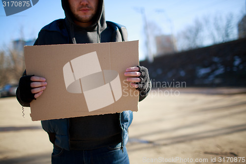 Image of Homeless man holds blank cardboard for your own text