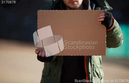 Image of Homeless man holds blank cardboard for your own text