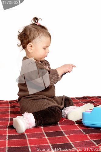 Image of Baby girl sitting on blanket.