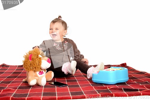 Image of Baby having fun with her toys.