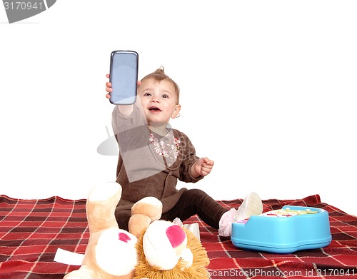 Image of Baby holding up a cell phone.