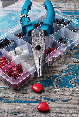 Image of box of beads for needlework on wooden table