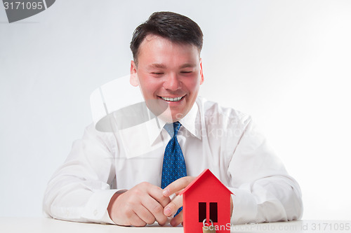 Image of Man with a red paper house