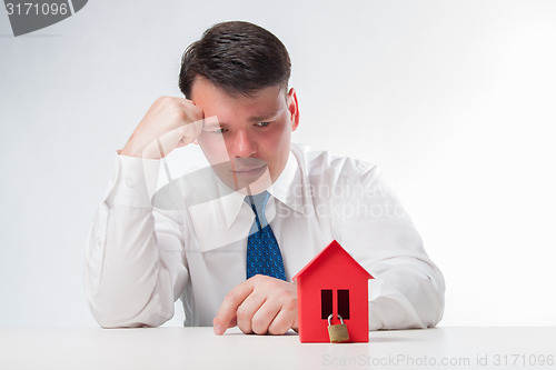 Image of Sad Man with a red paper house