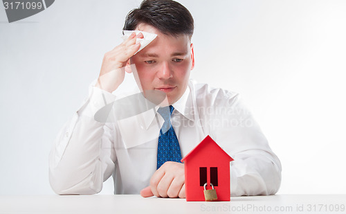 Image of Sad Man with a red paper house