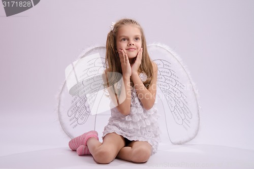 Image of Seated girl with angel wings