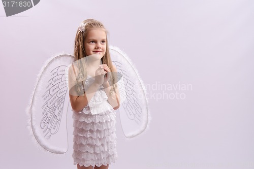 Image of girl dressed as an angel with wings folded hands