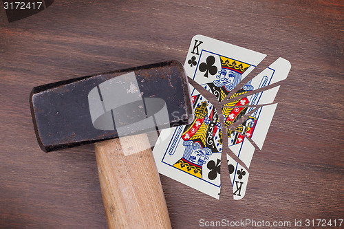 Image of Hammer with a broken card, king of clubs