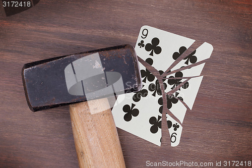 Image of Hammer with a broken card, nine of clubs