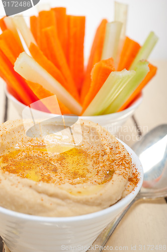 Image of fresh hummus dip with raw carrot and celery 