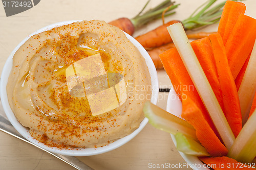 Image of fresh hummus dip with raw carrot and celery 