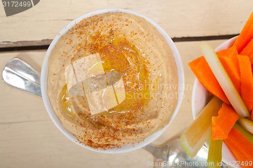 Image of fresh hummus dip with raw carrot and celery 