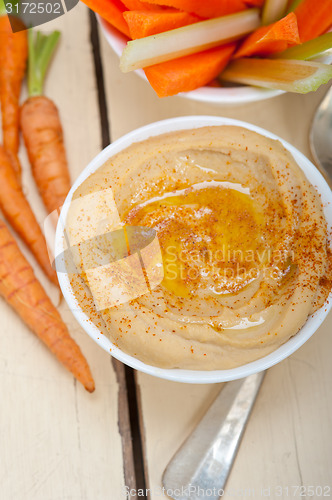 Image of fresh hummus dip with raw carrot and celery 